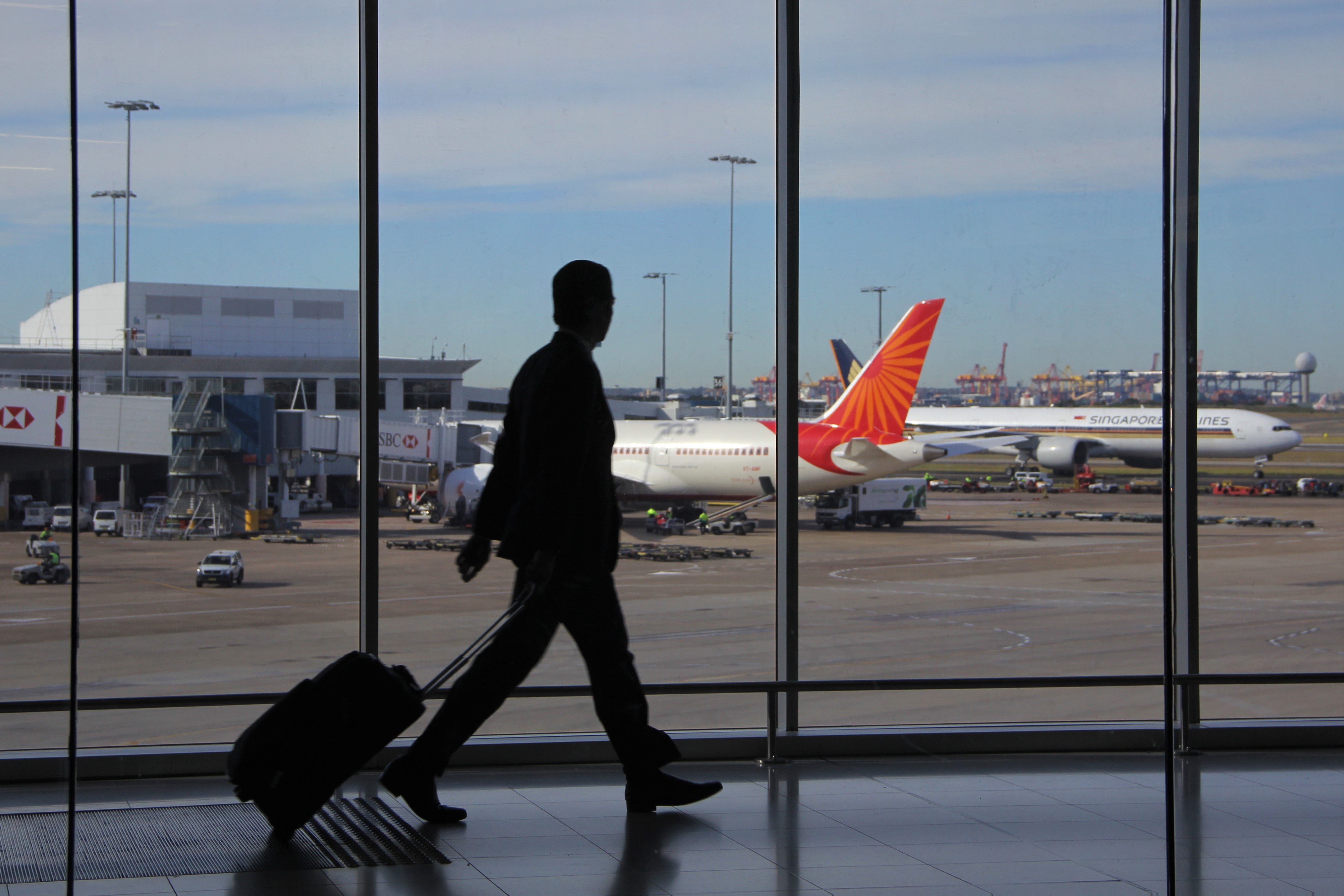 Airport traveller with a suitcase preparing documents for travel insurance before a trip